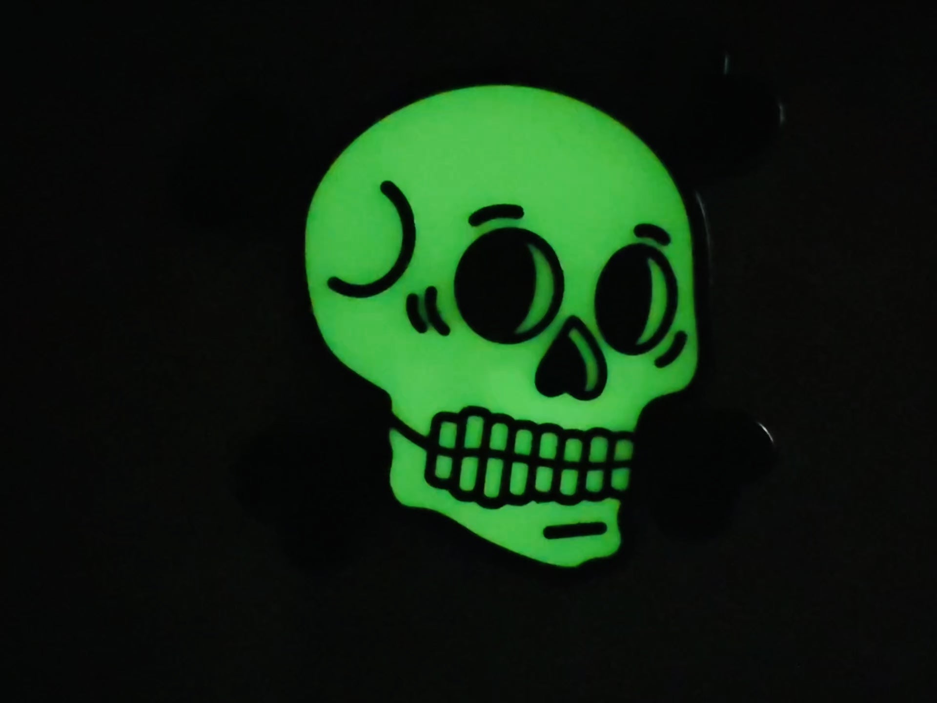 Glow-in-the-dark skull enamel pin for Halloween or gothic style, by Wick and Paper.