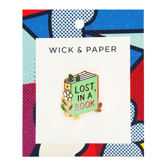 Book-themed enamel pin reading “Lost in a Book,” by Wick and Paper.