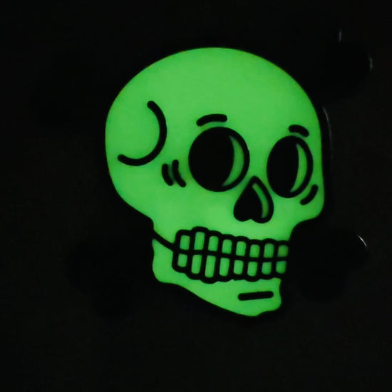 Glow-in-the-dark skull enamel pin for Halloween or gothic style, by Wick and Paper.