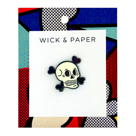 Glow-in-the-dark skull enamel pin for Halloween or gothic style, by Wick and Paper.